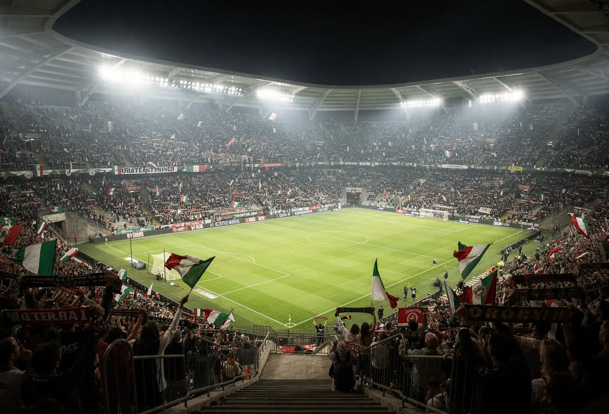 Atmosfera di uno stadio di calcio durante una partita serale di Serie A